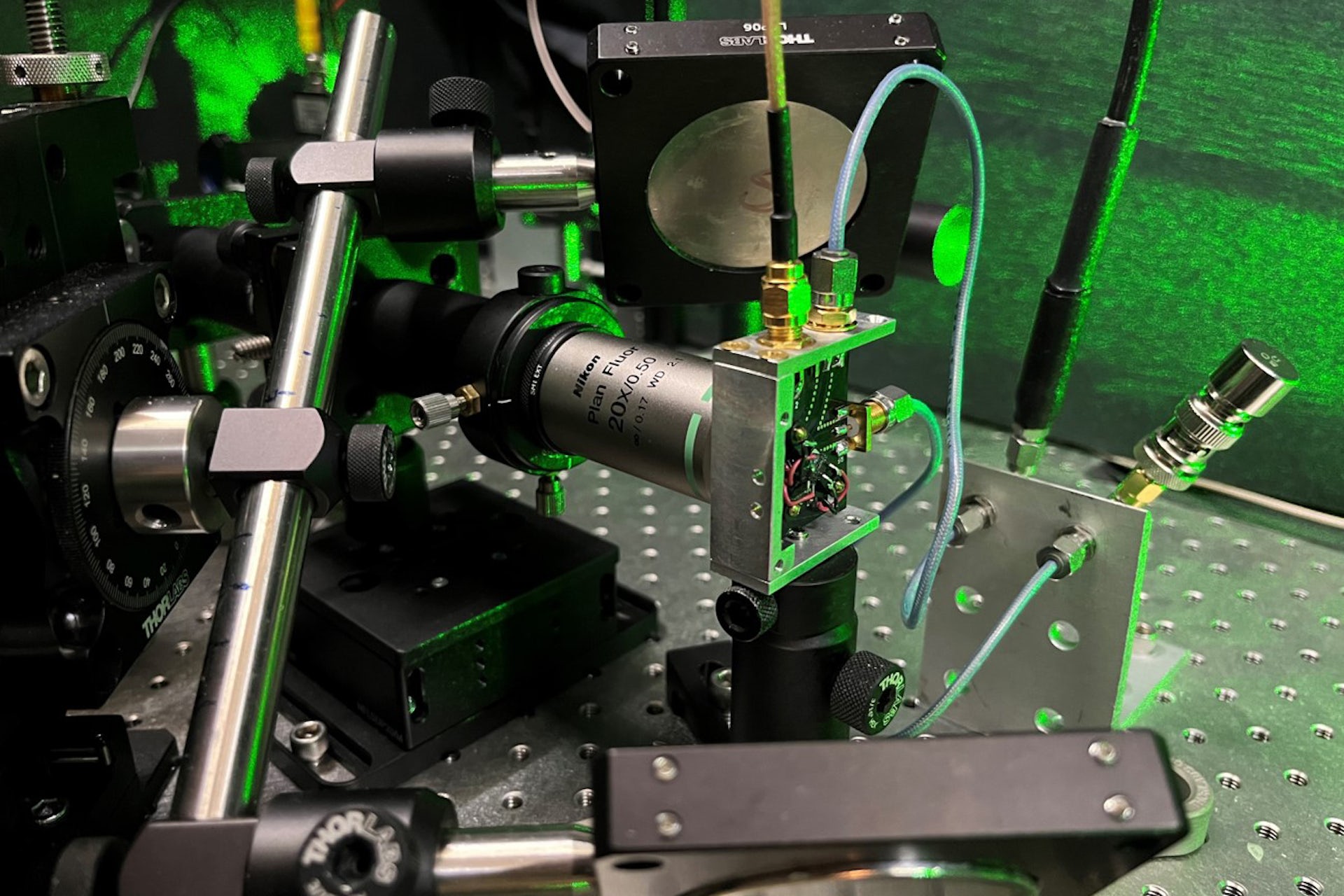 металевий апарат із зеленим лазерним світлом у фоновому режимі