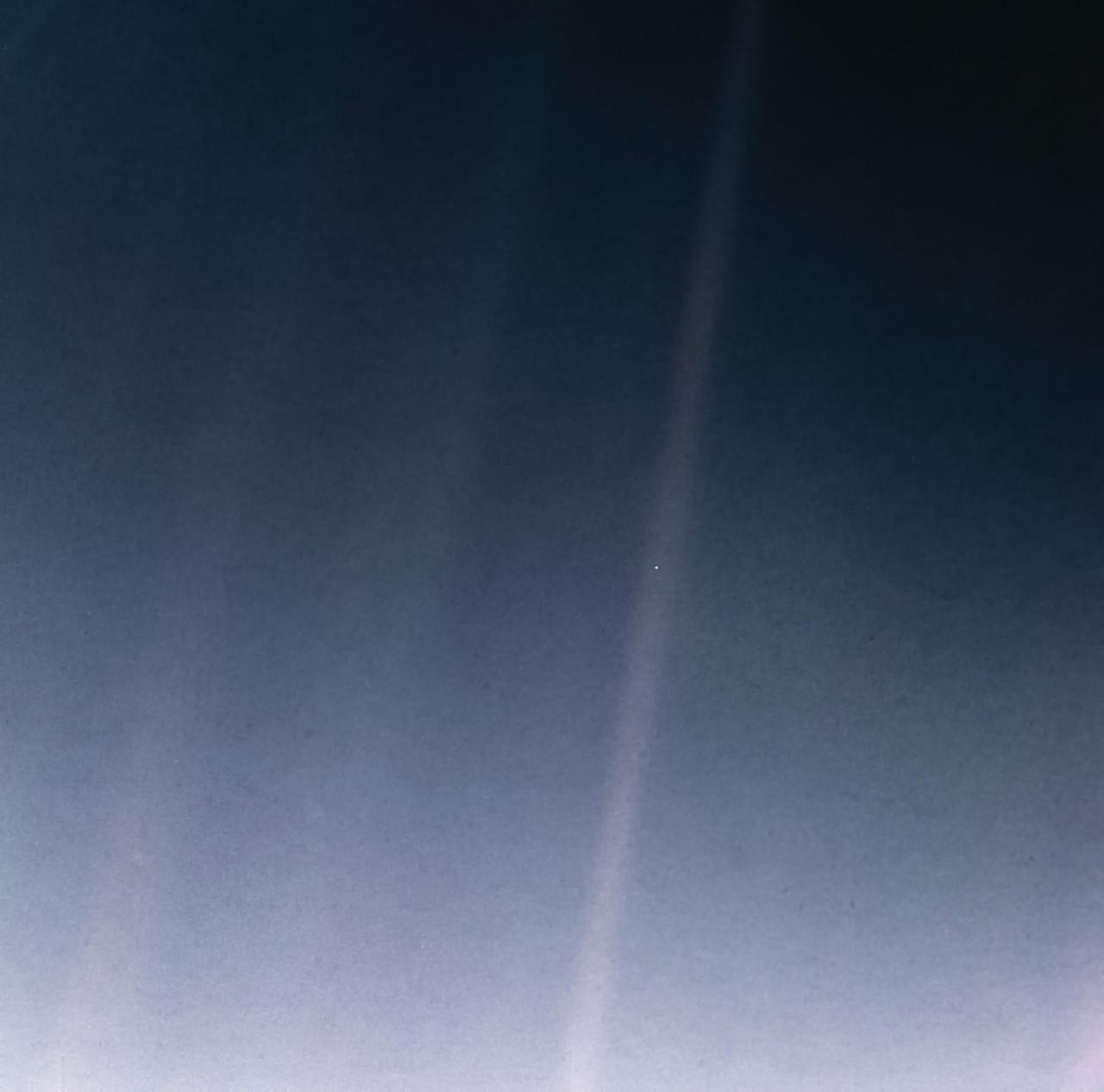 Перероблена версія фотографії Pale Blue Dot, зробленої місією «Вояджер» у 1990 році;  Планету Земля видно як крихітну білу цятку в центрі блакитно-сірого зображення