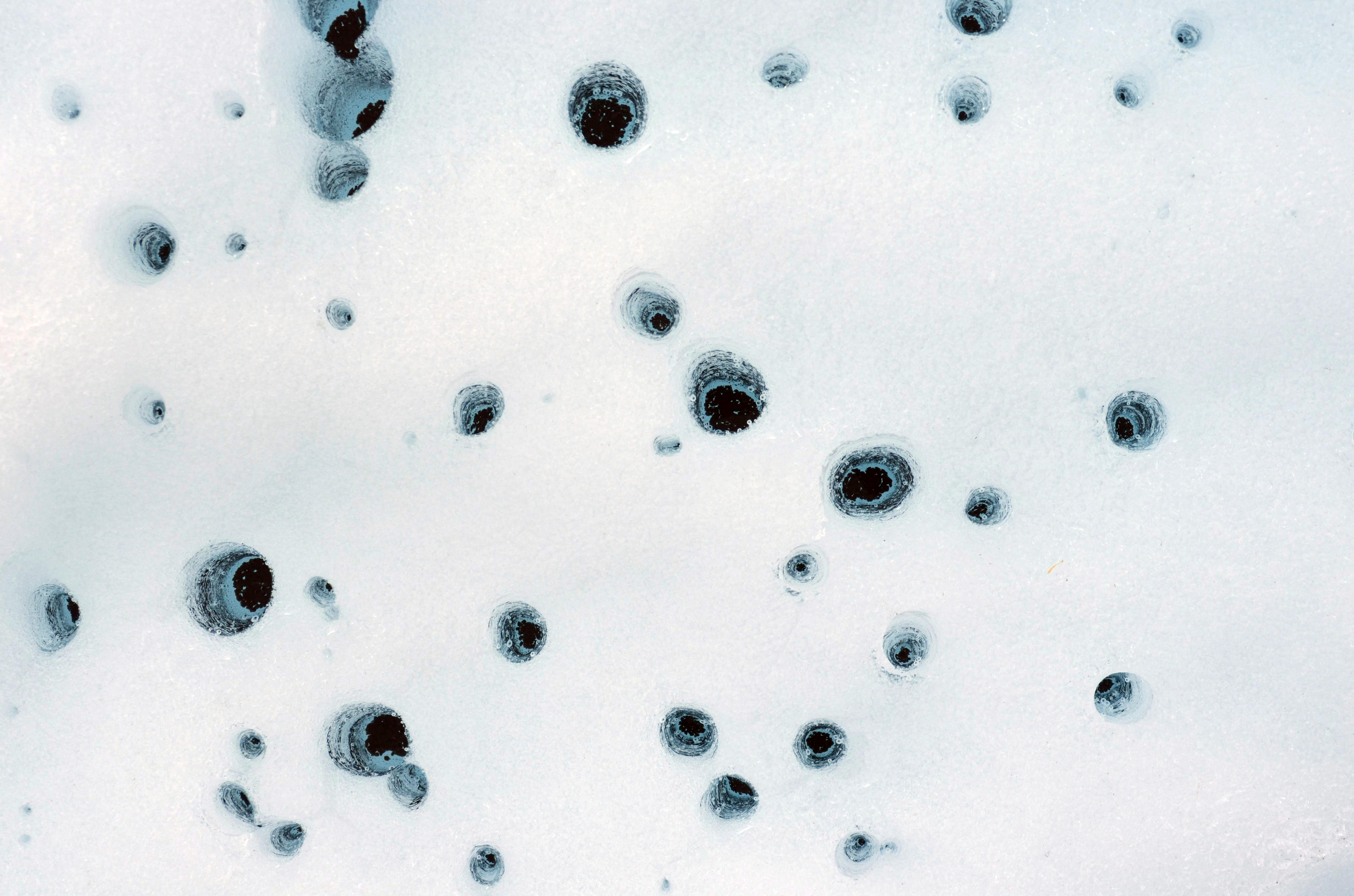 Holes formed on Alaska’s Matanuska Glacier by dust particles that melt into the ice over time, known as cryoconite. Eventually small pockets of water below the glacier’s surface form.